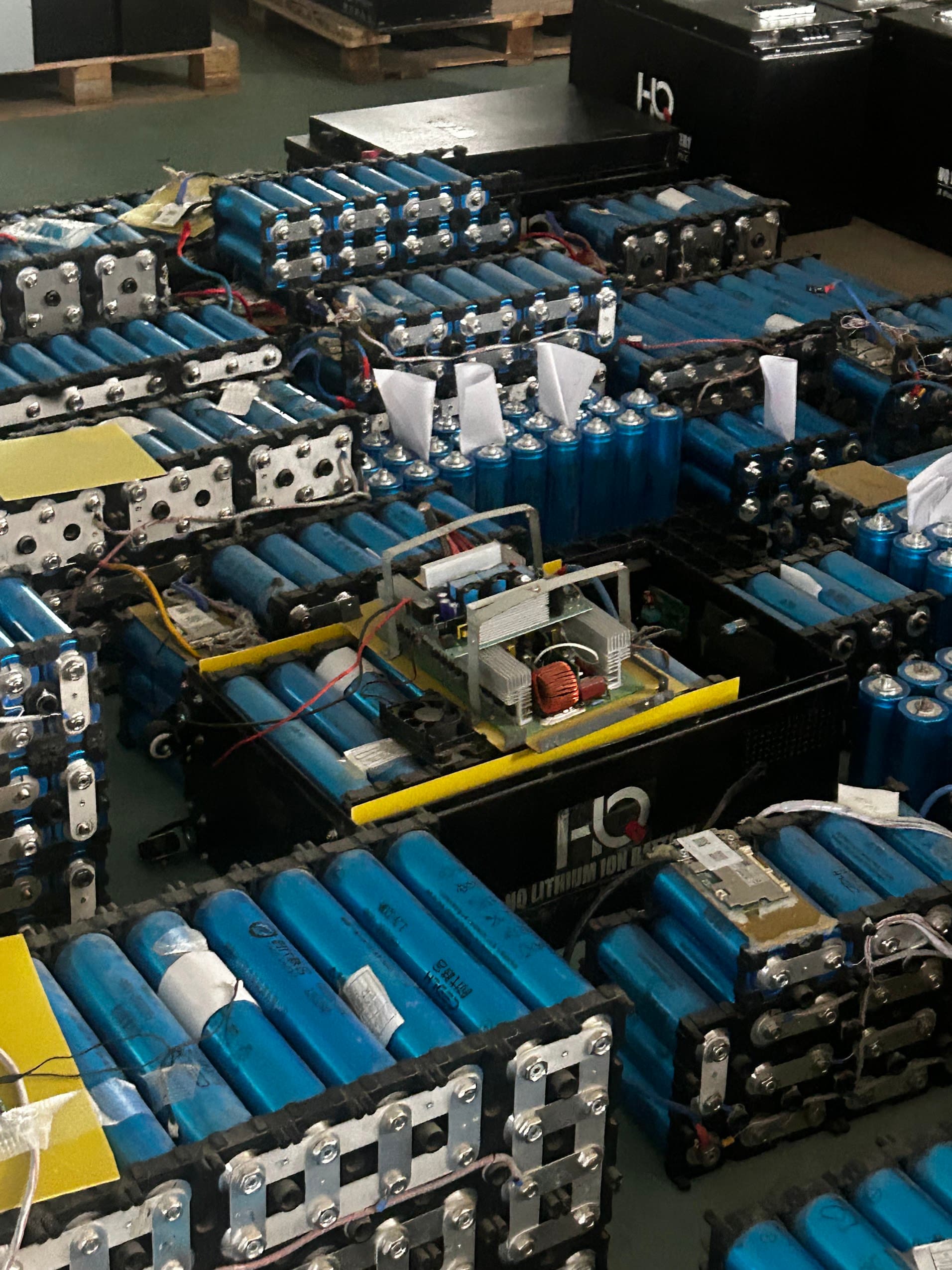 A workshop floor stacked with lithium-ion battery packs, Bangladesh 2026