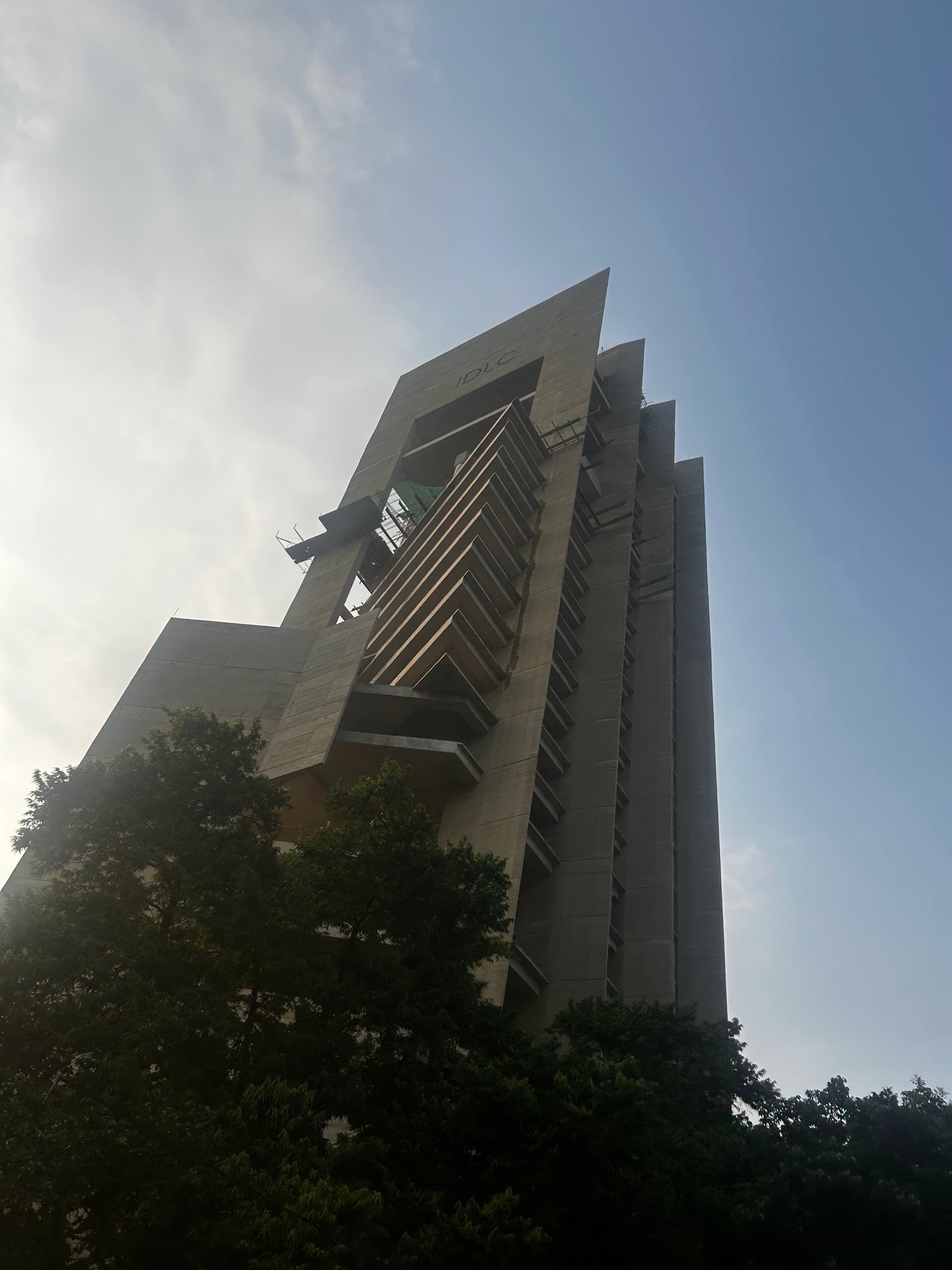 The concrete tower of a Bangladeshi finance company seen from below, Dhaka 2026