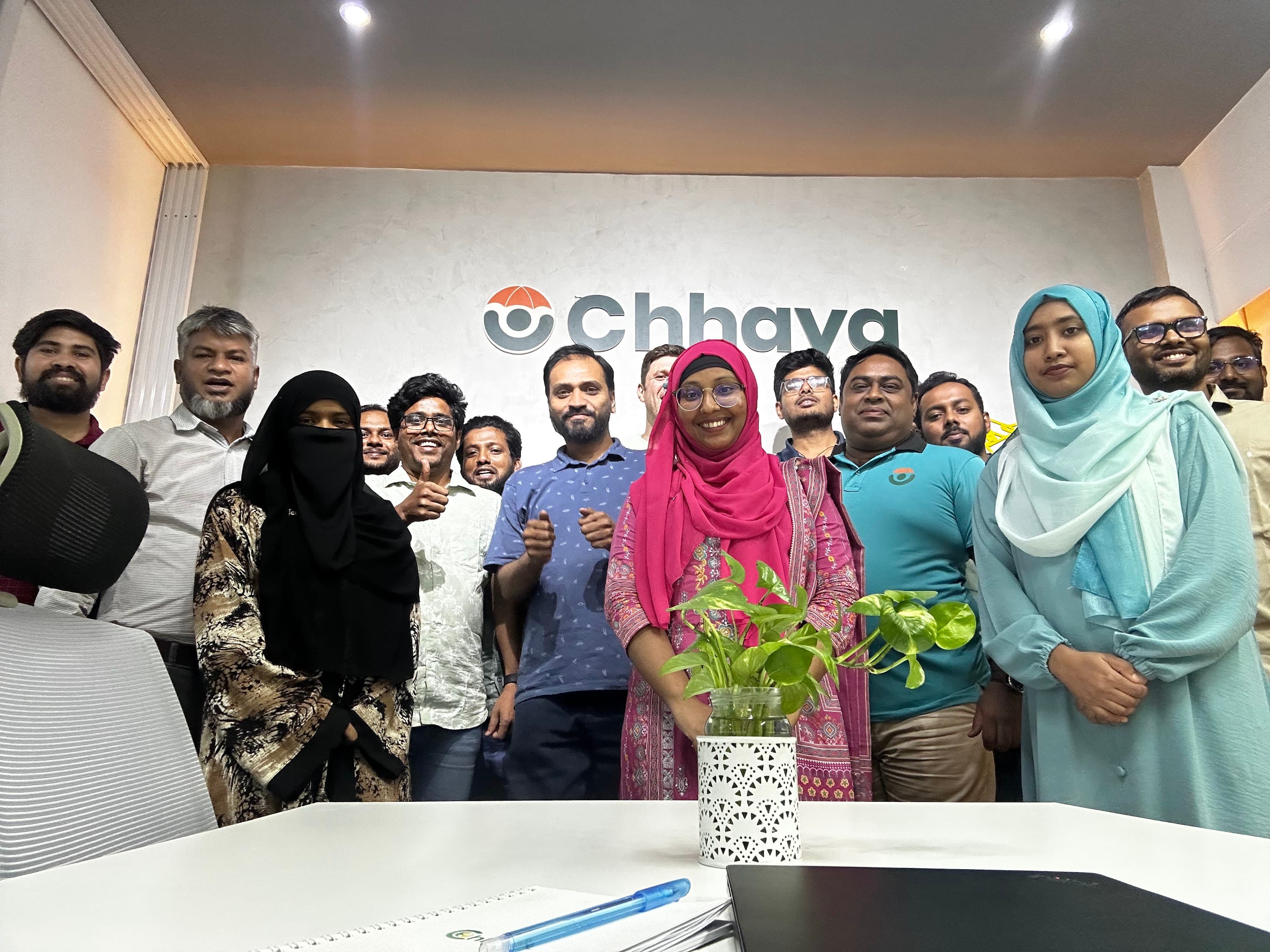 A Dhaka startup team gathered in a modern office, 2026